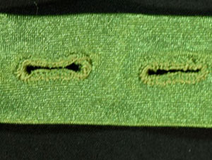 Two buttonholes worked on green spandex