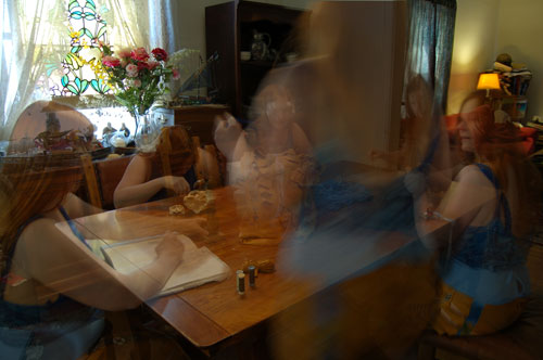A photograph, multiple exposure showing the outfit seven times around a work table doing different things
