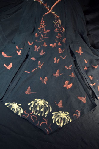 The front of the skirt on the dress, showing panels and painting of chrysantehemum-firework forms and butterflies dissolving down from an illusionistic belt