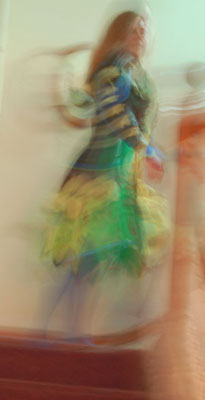 a ghostly image of a woman in the Persephone garments climbing a stair