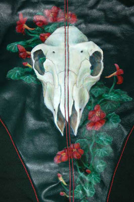 a sheep's skull and nasturtiums painted on the back of a leather jacket