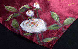 a white rose painted on maroon satin